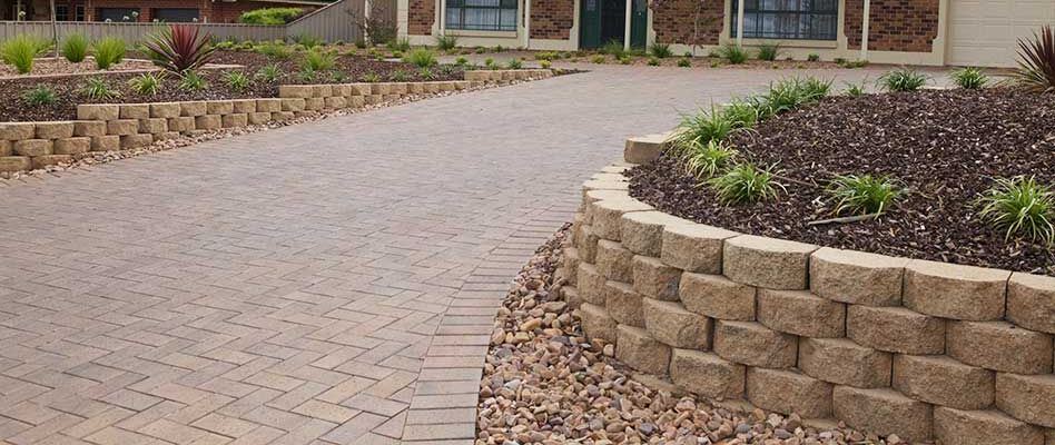 Segmental block retaining wall beside a paved driveway