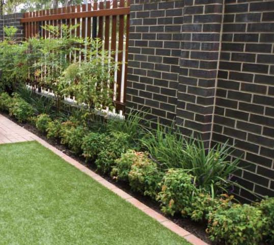 Paved courtyard with raised garden beds and new planting