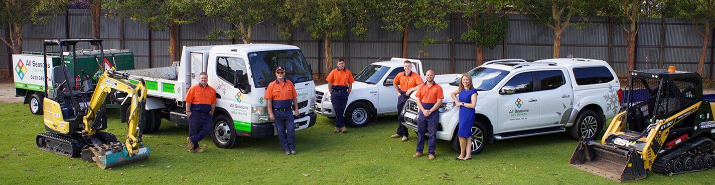 ASYS team standing beside their work vehicles